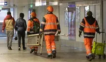 Pracownicy niosą drabinę na Dworcu Centralnym w Warszawie. 