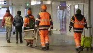 Pracownicy niosą drabinę na Dworcu Centralnym w Warszawie.