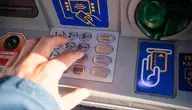 Mężczyzna wypłacający pieniądze w bankomacie