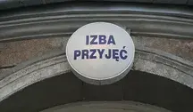 Wejście do izby przyjęć szpitala – znak z napisem ‘Izba Przyjęć’ nad wejściem, symbolizujący przeciążony system opieki zdrowotnej w Polsce i dramatyczny wzrost amputacji kończyn z powodu cukrzycy.