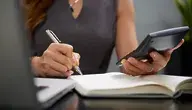 Kobieta z długopisem i kalkulatorem