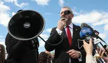 Grzegorz Braun przemawiając przez megafon