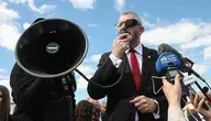 Grzegorz Braun przemawiając przez megafon