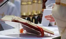 Otwarta Biblia na ołtarzu podczas mszy, widoczny fragment szaty liturgicznej kapłana. Zdjęcie ilustruje temat artykułu o tradycyjnym odczytywaniu Pisma Świętego kontra lewicowe queerowe interpretacje Biblii