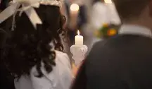 Dziecko trzymające świecę podczas komunii