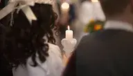Dziecko trzymające świecę podczas komunii