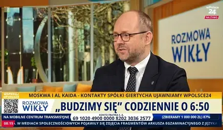 Marcin Przydacz w programie Rozmowa Wikły na żywo w Polsce24, omawia politykę zagraniczną i obronną, siedząc na tle nowoczesnego wnętrza.