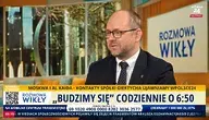Marcin Przydacz w programie Rozmowa Wikły na żywo w Polsce24, omawia politykę zagraniczną i obronną, siedząc na tle nowoczesnego wnętrza.