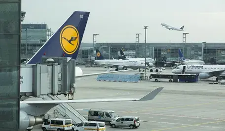 Samolot pasażerski Lufthansy na lotnisku, symbolizujący ograniczanie połączeń i odwoływanie lotów przez przewoźnika w związku z kryzysem paliwowym i restrukturyzacją.
