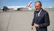 Premier Donald Tusk na tle samolotu