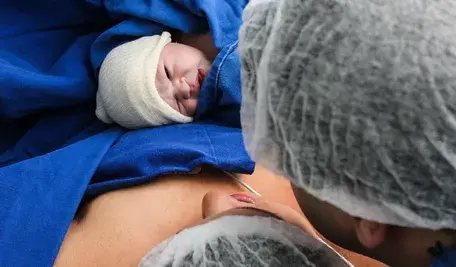 Niemowlę trzymane przez matkę na łóżku szpitalnym