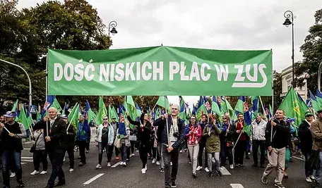 Pracownicy ZUS podczas protestu niosący zielony transparent