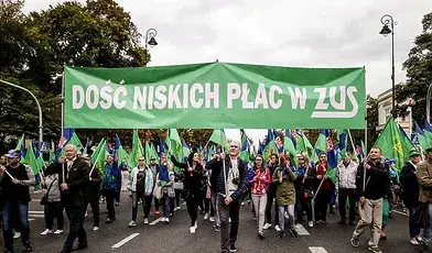 Pracownicy ZUS podczas protestu niosący zielony transparent