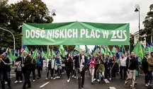 Pracownicy ZUS podczas protestu niosący zielony transparent