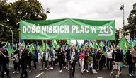 Pracownicy ZUS podczas protestu niosący zielony transparent