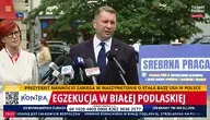 Przemysław Czarnek podczas konferencji prasowej przed mikrofonami, w tle plansza informacyjna i hasła o wydarzeniach w Białej Podlaskiej.