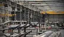 Wnętrze hali przemysłowej z konstrukcją stalową, liniami produkcyjnymi i elementami metalowych profili.