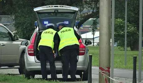 Policjanci podczas czynności służbowych przy radiowozie