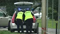 Policjanci podczas czynności służbowych przy radiowozie