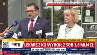 Konferencja prasowa polityków przed wejściem do szpitala w Warszawie. Mężczyzna w garniturze i czerwonym krawacie oraz kobieta w jasnej marynarce przemawiają do mediów, przed nimi ustawione są mikrofony telewizyjne. W tle widoczne wejście do budynku szpitala oraz oznaczenia transmisji na żywo.