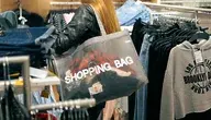 Kobieta z torbą na ramieniu podczas zakupów w sklepie odzieżowym
