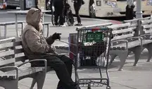Bezdomny mężczyzna siedzący na ławce