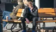 Zrezygnowany młody mężczyzna siedzi na ławce w mieście, z głową opartą na dłoni, ilustrując problem bezrobocia i rosnących długów wśród młodych Polaków