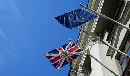 Flagi Unii Europejskiej i Wielkiej Brytanii na tle Londynu – debata o możliwym powrocie UK do UE po latach od brexitu