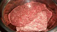 Surowe mięso mielone wołowe i wieprzowe w stalowej misce, widok z bliska na produkt mięsny używany w kuchni do przygotowania potraw takich jak kotlety czy sosy.