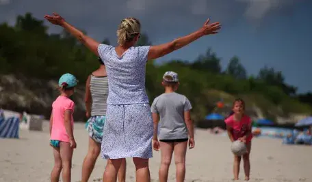 Kobieta bawiąca się z dziećmi na plaży