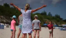 Kobieta bawiąca się z dziećmi na plaży