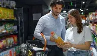 Mlodzi ludzie w sklepie z butelką soku