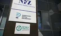 Zewnętrzna tablica informacyjna Narodowego Funduszu Zdrowia oraz Warszawskiego Szpitala Południowego umieszczona na elewacji budynku. Widoczne są także oznaczenia szybkiej terapii onkologicznej, wskazujące na działalność placówki w zakresie leczenia pacjentów onkologicznych.