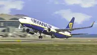 Samolot Ryanair w trakcie startu z pasa startowego, uchwycony w dynamicznym momencie wznoszenia się maszyny nad lotniskiem. W tle widoczna infrastruktura terminala oraz niebo z lekkim zachmurzeniem, co podkreśla ruch i intensywność operacji lotniczych. Ujęcie ilustruje kontekst działalności przewoźnika w segmencie tanich lotów, gdzie kluczową rolę odgrywa szybka rotacja i wysoka intensywność operacyjna.
