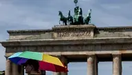 epa13068609 A pedestrian shelters from the sun under an umbrella in front of Brandenburg Gate during high temperatures in Berlin, Germany, 27 June 2026. The German Weather Service (DWD) recorded a preliminary all-time record high of 41.3 degrees Celsius on 26 June near Saarbruecken. EPA/FILIP SINGER Dostawca: PAP/EPA.