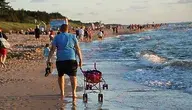 Mężczyzna z wózkiem spacerujący po plaży