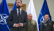 Wicepremier i szef MON Władysław Kosiniak-Kamysz przemawia przy mikrofonie podczas konferencji wojskowej, w tle polskie i NATO-wskie flagi oraz oficerowie Wojska Polskiego – ilustracja do artykułu o nowej stałej bazie USA w Polsce