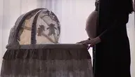 Kobieta w ciąży przy dziecięcym łóżku