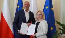 Minister sportu i wiceminister Żaneta Cwalina-Śliwiowska podczas oficjalnego wręczenia dokumentów powołania w resorcie sportu w Polsce, z flagami Polski i Unii Europejskiej w tle