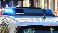 Niebieskie światła na dachu radiowozu policyjnego podczas interwencji – zdjęcie ilustracyjne.