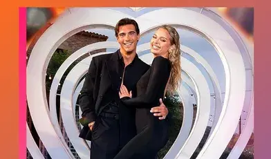 Para ubrana na czarno pozuje przed dekoracją w kształcie serca po zwycięstwie w brytyjskim „Love Island”.
