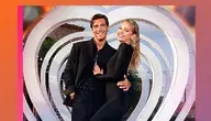 Para ubrana na czarno pozuje przed dekoracją w kształcie serca po zwycięstwie w brytyjskim „Love Island”.