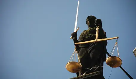 Symboliczna figura Temidy z wagą i mieczem ilustrująca sprawę sądową dotyczącą stalkingu małżeństwa Steinerów przez byłych pracowników eBay