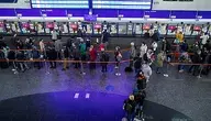 Pasażerowie czekający w kolejce do kasy biletowej PKP