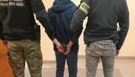 Policjant i funkcjonariusz Straży Granicznej eskortują skutego kajdankami 34-letniego obywatela Kolumbii zatrzymanego po incydencie w Muzeum Auschwitz-Birkenau.
