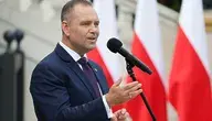 Prezydent Karol Nawrocki przemawiający na tle biało-czerwonych flag