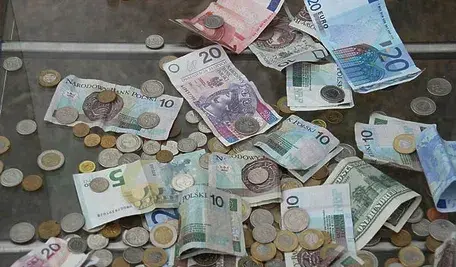 Pieniądze rozrzucone na szklanym stole