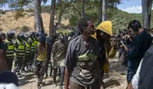 Migranci z Afryki Subsaharyjskiej eskortowani przez służby bezpieczeństwa w pobliżu granicy Maroka z hiszpańską enklawą Ceuta