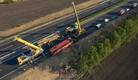 Rozbity autokar polskich pielgrzymów leżący na boku na poboczu autostrady M3 na Węgrzech. Służby ratunkowe i straż pożarna na miejscu. Do wypadku doszło w okolicy miejscowości Mezőkeresztes.
