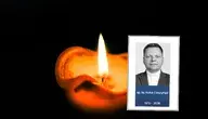 Świeca na czarnym tle i zdjęcie zmarłego księdza